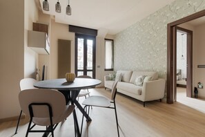 Una sala moderna con una mesa redonda para comer, un sofá y una pared con diseño.