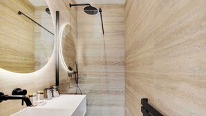 Un bagno moderno con uno specchio grande, un lavandino bianco e uno spazio doccia.
