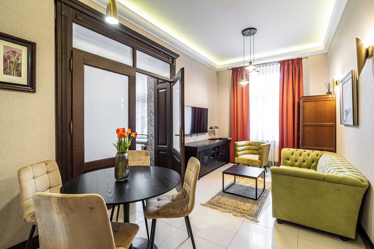 A modern living room with a dining area, a sofa, a TV, and a wooden cabinet.