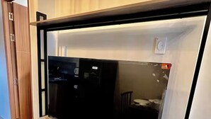Un mueble moderno para entretenimiento con televisor de pantalla plana, detalles de madera y cajones de almacenamiento integrados.