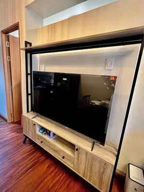 Ein modernes Unterhaltungseinheit mit Fernseher, Holzoptik und integrierten Stauraumschubladen.