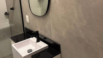 Een douche, handdoeken, zeep, toiletpapier