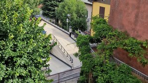 A hillside residential area with houses, a paved road, and a view of the sea. - Monti Como Lake apartament (Brunate)