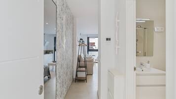 Een moderne badkamer met een wit wastafel, spiegel en handdoekhouder.