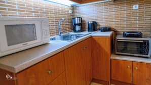 Una cocina equipada con microondas, cafetera, tostadora y fregadero.