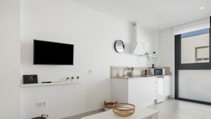 Een moderne keuken met een flatscreen televisie, een klok en een magnetron.