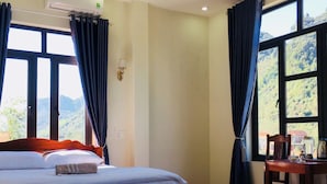 Ein Hotelzimmer mit einem Bett, einem Tisch mit Wasserkocher und Vorhängen.