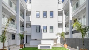 En moderne bygning med en central gårdsplads, flere etager og plantekasser.