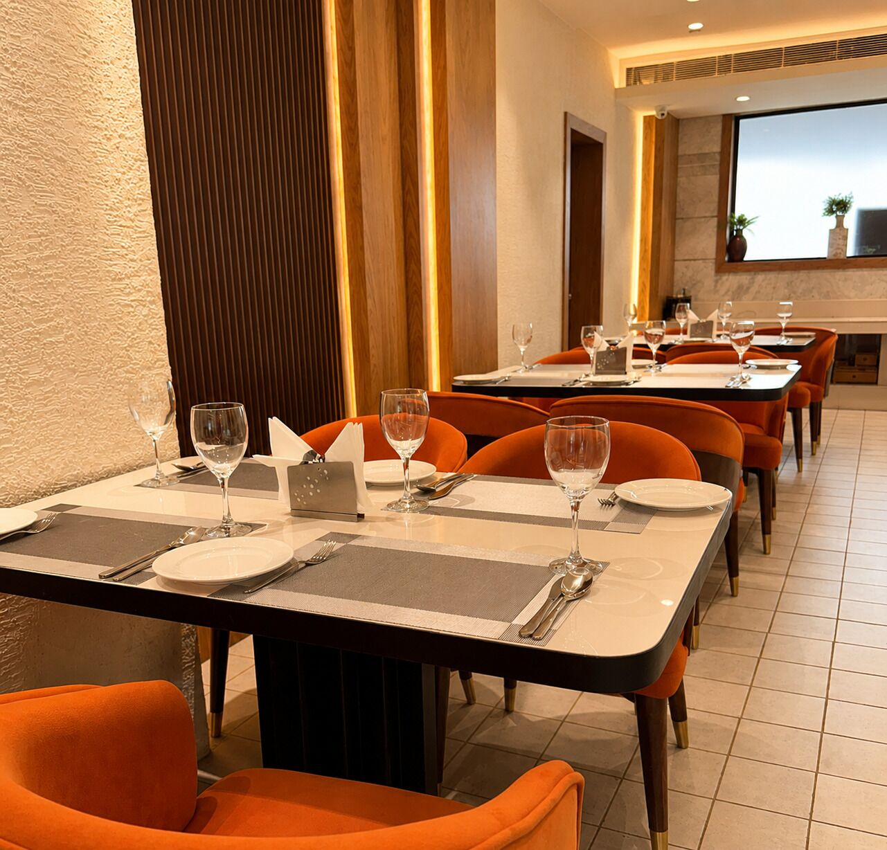 Comedor con mesas dispuestas para el servicio, sillas y vistas de la sala.