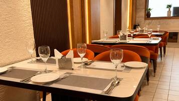 Comedor con mesas dispuestas para el servicio, sillas y vistas de la sala.
