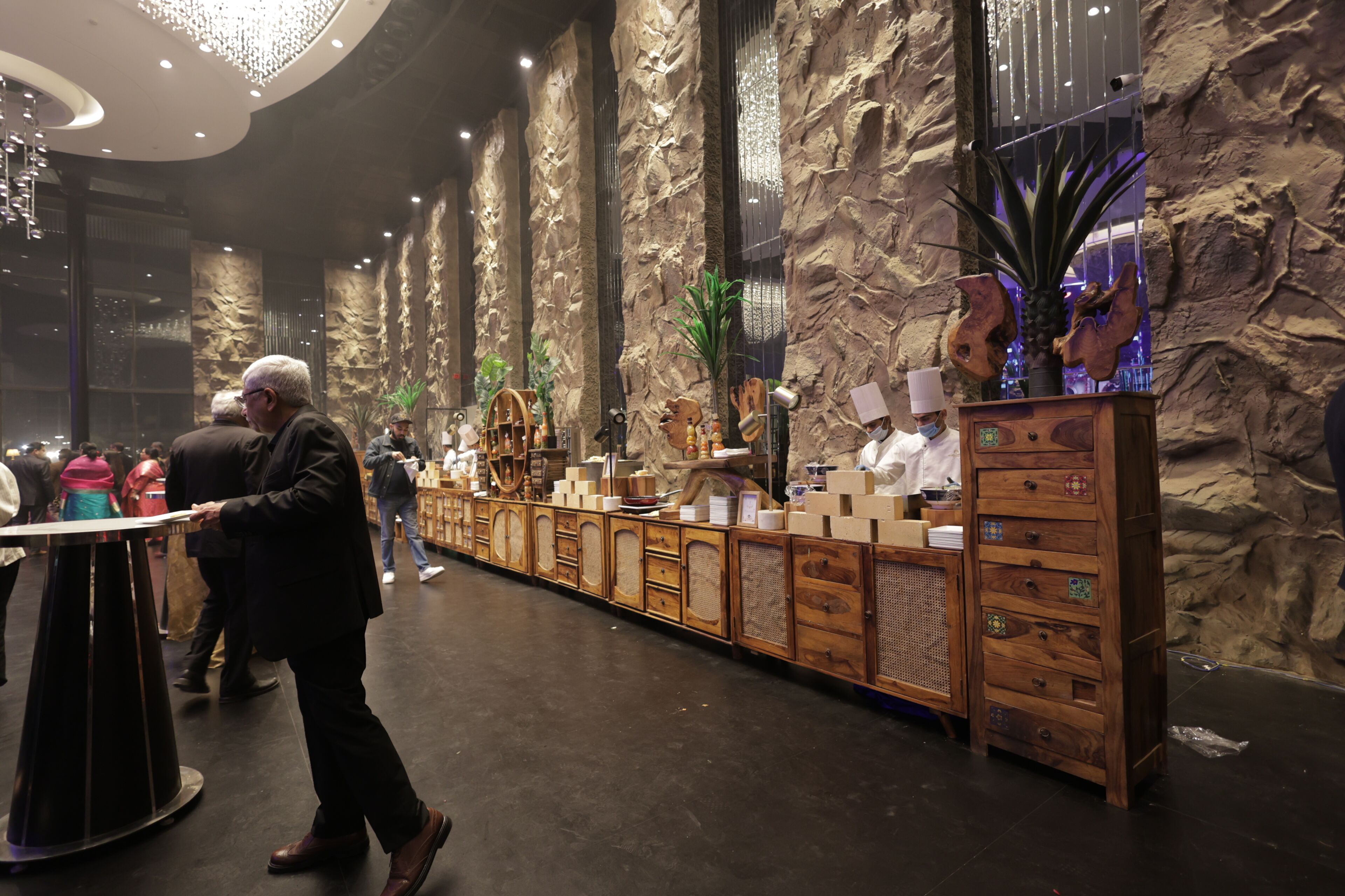 A reception area with a long counter, wooden cabinets, and a large decorative plant.