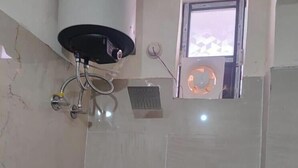 A bathroom with a shower, a sink, and a window. - Panchmukhi Home Stay  (Varanasi)