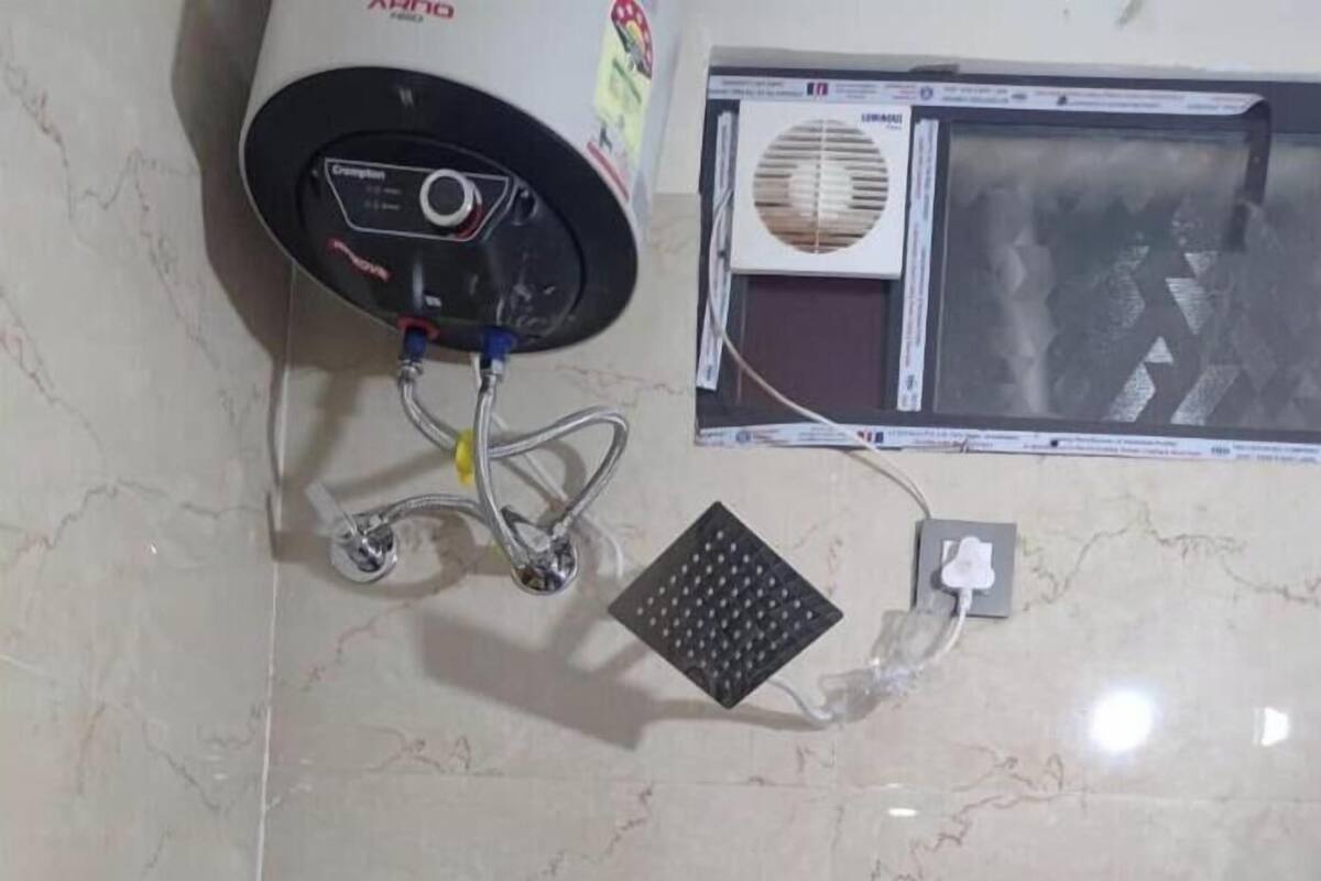 A bathroom with a hand dryer, a power outlet, and a vented window.
