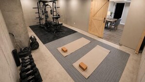 A gym with weightlifting equipment, mats, and a sliding door. - 5BR Pool Oasis | Firepit & Group Retreat (Wentzville)