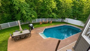 A backyard with a swimming pool, patio furniture, and a fenced area. - 5BR Pool Oasis | Firepit & Group Retreat (Wentzville)