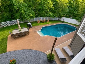 A backyard with a swimming pool, patio furniture, and a fenced area. - 5BR Pool Oasis | Firepit & Group Retreat (Wentzville)