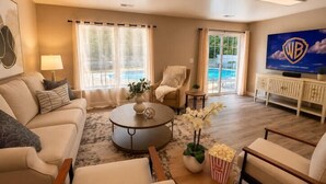 A living room with a sofa, armchairs, a coffee table, and a TV. - 5BR Pool Oasis | Firepit & Group Retreat (Wentzville)