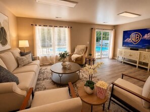 A living room with a sofa, armchairs, a coffee table, and a TV.