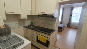 A compact kitchen with a built-in oven, a sink, and a small countertop. - Group Stay 3 Apts Near Enkplatz (Vienna)