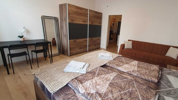 A bedroom with a bed, a desk, a chair, a sofa, and a wardrobe. - Group Stay 3 Apts Near Enkplatz (Vienna)
