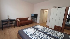 A bedroom with a bed, a sofa, a desk, a TV, and a wardrobe. - Group Stay 3 Apts Near Enkplatz (Vienna)