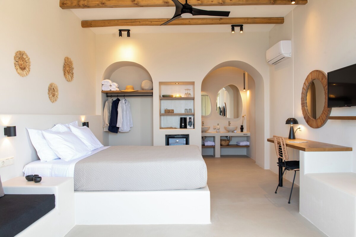 Ein modernes Schlafzimmer mit einem großen Bett, einem Schreibtisch und einem Schminktisch.