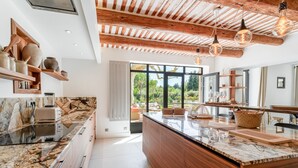 Une cuisine moderne dotée d’un plan de travail en marbre, de meubles en bois et d’un grand îlot central.