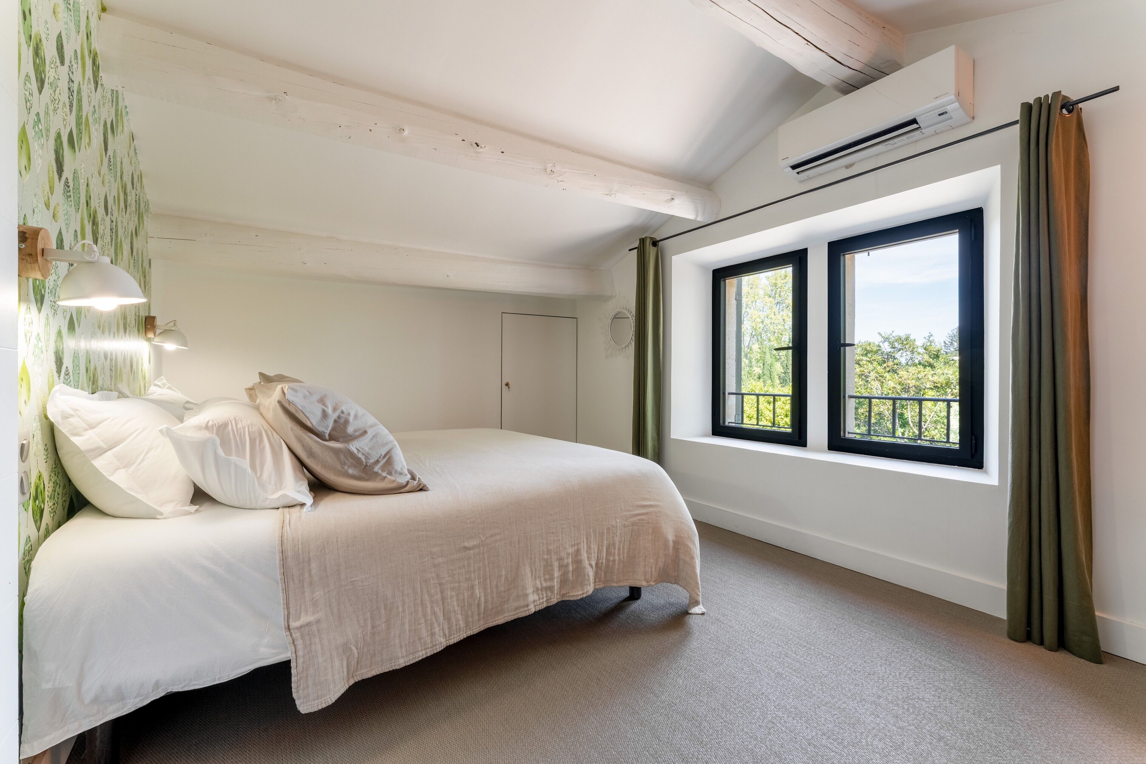 A bedroom with a bed, a window, and an air conditioning unit.