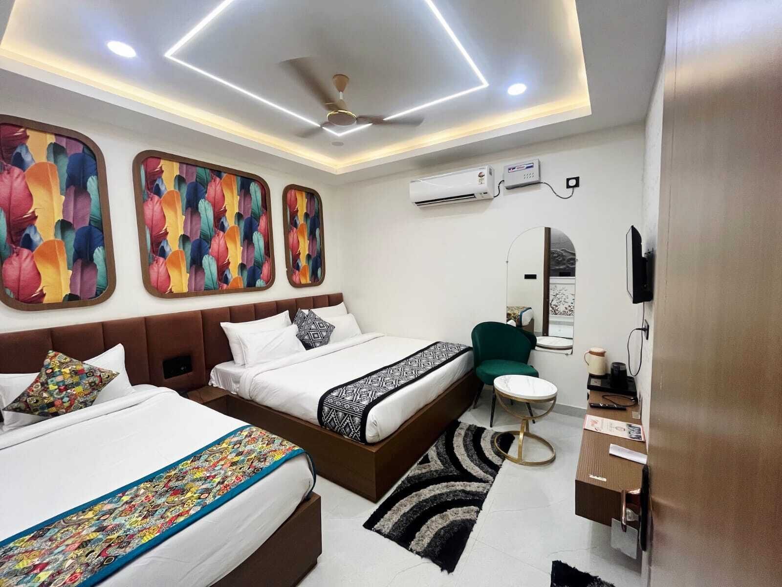 A modern hotel room with a bed, bedside table, and a small seating area.