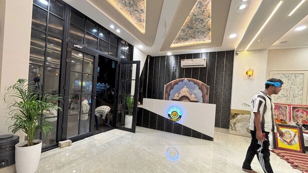 A hotel lobby with a reception desk, a large potted plant, and a marble floor. - The Golden Taj Vrindavan (Vrindavan)