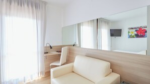 A modern hotel room with a large bed, a desk with a chair, a flat-screen TV, and a large mirror. - Albergo Ristorante Belvedere (Codroipo)