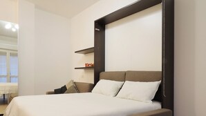 Un dormitorio moderno con cama, mesita de noche, estante empotrado y lámpara en el techo.
