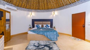 Un dormitorio con cama, mesitas de noche, armario, puerta y ventilador de techo.