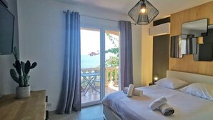 A hotel room with a bed, a potted plant, a sliding glass door to a balcony, and a ceiling light fixture. - Villa Premium à Saint-Raphaël - Heated pool, 6 suites and sea view (Saint-Raphaël)