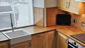 Una cocina moderna con armarios de madera, horno empotrado y una mesa de comedor.