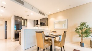 Un espace repas moderne avec un îlot central, quatre chaises et une table dressée pour quatre personnes.