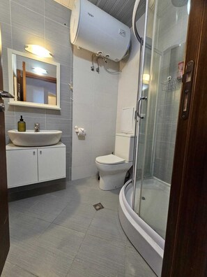 Ein modernes Badezimmer mit Toilette, Waschbecken und Dusche.