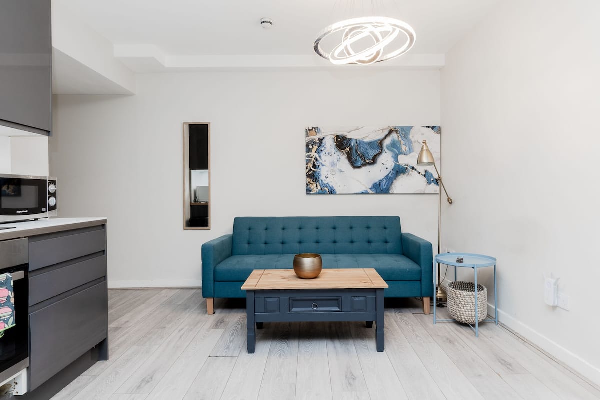 A modern living room with a sofa, coffee table, and artwork on the wall.