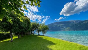 A grassy area with trees and a lake. - Surfers Deck | Terrace & Lake View (Därligen)