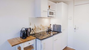 A compact kitchenette with a microwave, coffee maker, and a small refrigerator. - Surfers Studio | Lake View & Pool (Därligen)