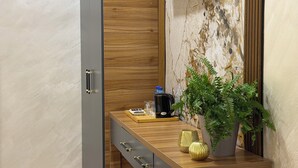 A modern kitchen with a wooden countertop, a built-in coffee machine, and a potted plant. - Welcome Inn Hotel (Tashkent)