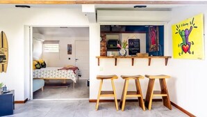 A compact living space with a kitchenette, a bed, and a small dining area with stools. - La Rose Bleue - Your renovated cocoon a stone's throw from Le Diamant beach (Le Diamant)