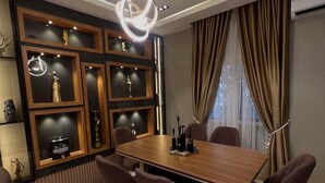 Ein stilvolles Esszimmer mit einem Holztisch, sechs Stühlen und einer dekorativen Deckenleuchte.
