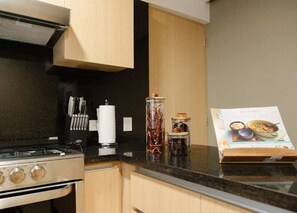 A kitchen with a stove, cabinets, and a cookbook on the counter. - HOM Elba Retreat Trendy 2 BR in Mexico City (Mexico City)