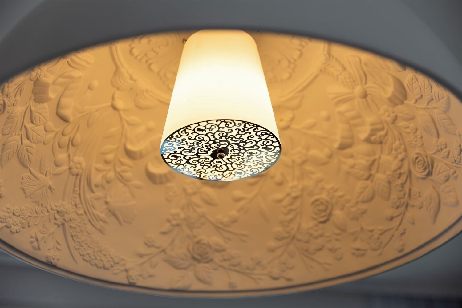 A ceiling with intricate floral and geometric patterns.