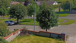 A white sports car parked in a driveway with a brick wall and a flower bed. - Room-calm and Warm Place Near to the tow (Cavan)