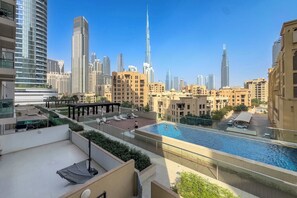 A rooftop pool with a city skyline in the background. - Stayshort - Downtown 2 Bed Unit With Burj Views That Sleeps 4 (Dubai)
