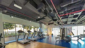 Un gimnasio con cintas de correr, pelotas de ejercicio y máquinas de pesas.