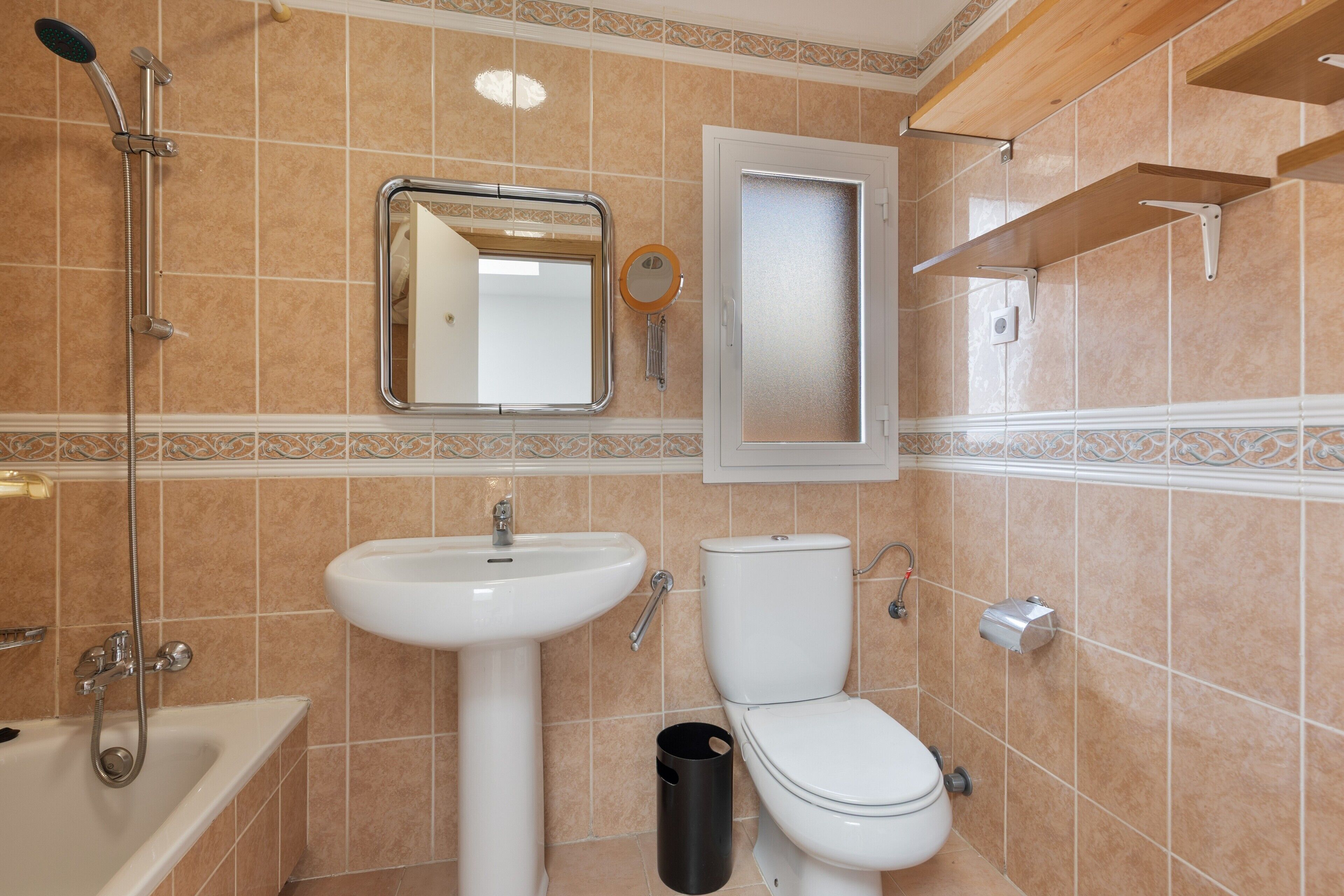 A bathroom with a bathtub, sink, toilet, and a mirror.