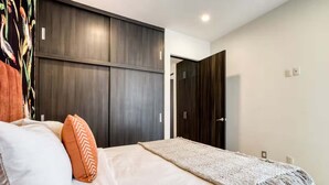 A bedroom with a bed, a large wardrobe, and a door leading to another room. - HOM Roma Double l Spacious 2 Bedroom in Mexico City (Mexico City)